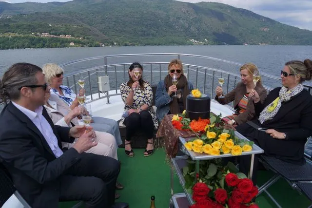 Trauergemeinde stößt an Bord eines Schiffes bei einer Seebestattung gemeinsam an