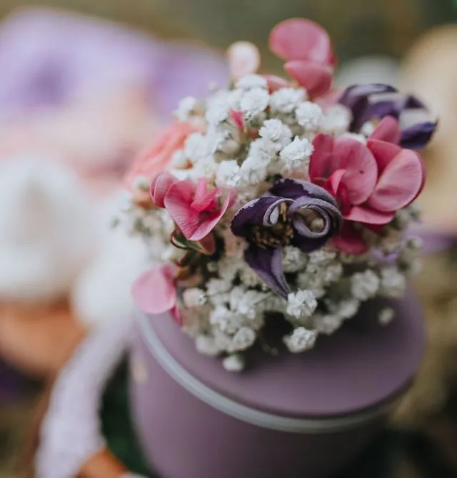 Urne mit zartem Blumenschmuck aus Schleierkraut und rosafarbenen Blüten als liebevolle Abschiedsgestaltung