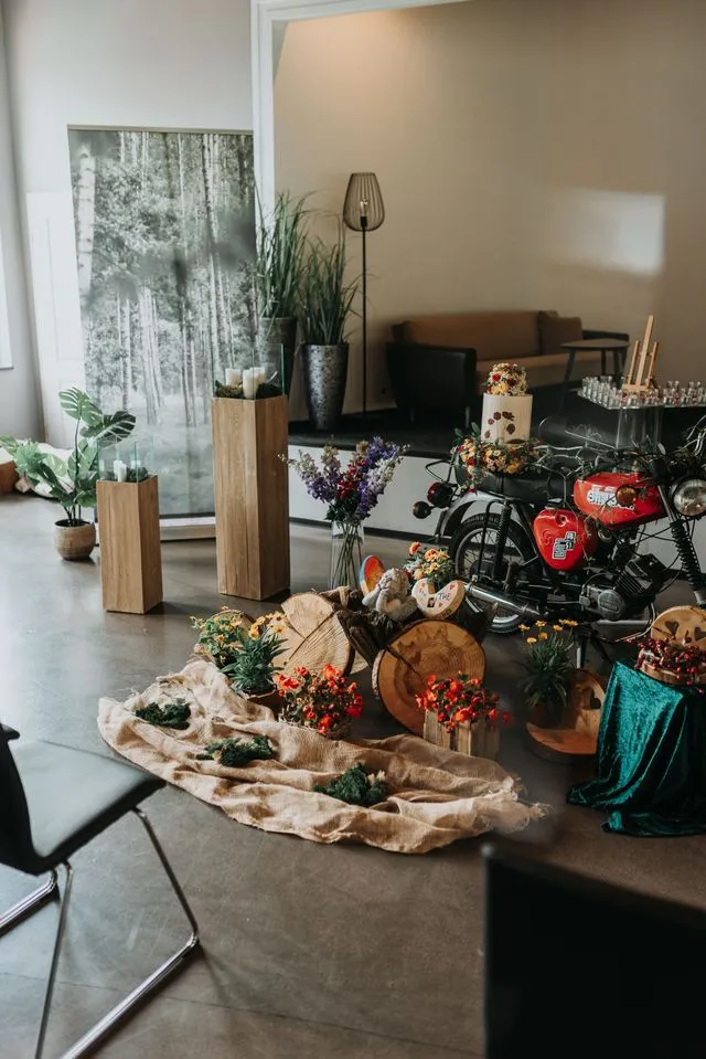 Individuelle Trauerdekoration mit Simson-Motorrad, Blumen und Holzobjekten in einer Abschiedshalle