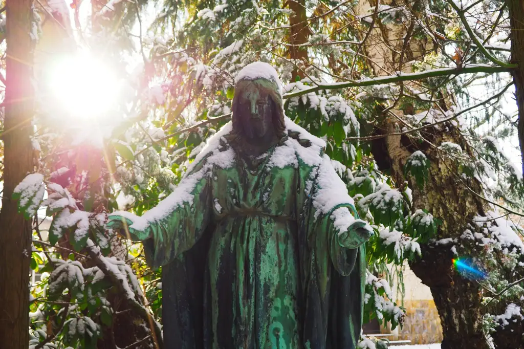 Denkmalfigur auf dem Friedhof Matthaeus-Friedhof in Chemnitz im warmen Sonnenlicht zwischen alten Bäumen